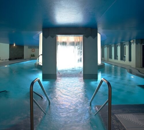 Enorme piscina de hidroterapia con cascada de agua en la parte central en el spa del hotel Hotel SPA TermaEuropa Balneario Arnedillo
