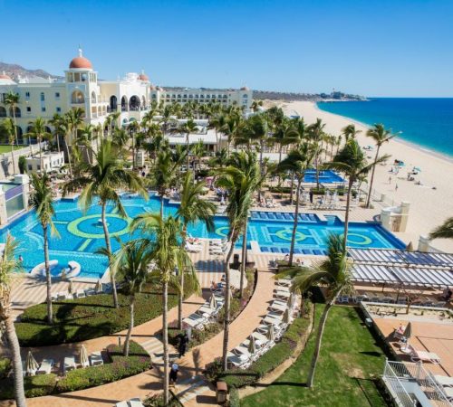 Vista de la playa, las palmeras, las piscinas y las instalaciones del hotel Riu Palace Cabo San Lucas - All Inclusive
