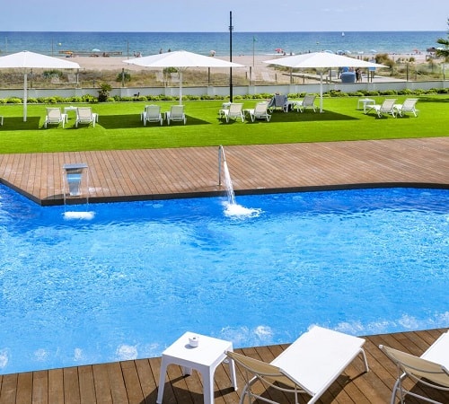 Vista de la piscina junto a la playa en el hotel con vistas al mar de Barcelona Hotel Playafels