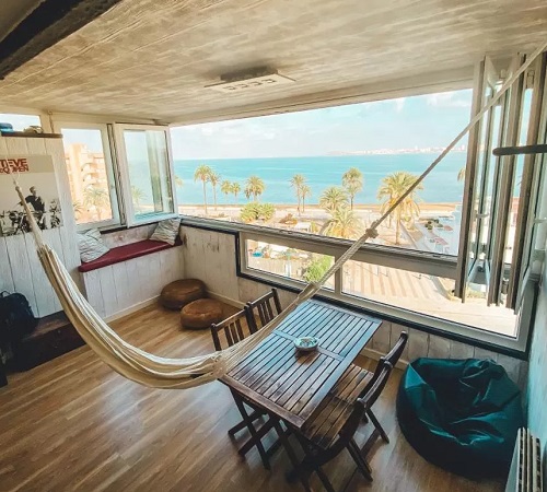 Foto del Apartamento Impresionantes Vistas al Mar Menor donde vemos un gran ventanal y una paraguaya desde donde se puede ver el mar