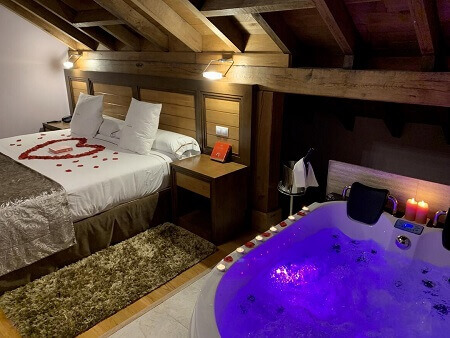 Foto de una hotel con suite para parejas con jacuzzi en la habitaciÃ³n junto a la cama ideal para ir con tu pareja