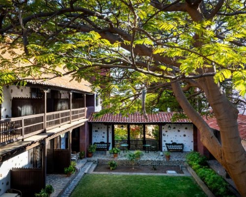 Foto del patio interior del Parador de La Gomera donde se pueden ver los típicos árboles de origen canario y las fachadas típicas de estilo colonial.