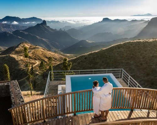 Foto de una pareja sobre la terraza que hay sobre la piscina con vistas al valle en Parador de Cruz de Tejeda