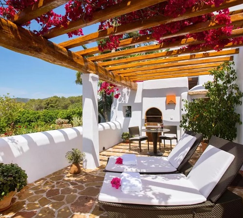 Habitación con terraza y llena de flores con vistas al campo en Hotel Rural & Spa Can Curreu ideal para tomar el sol y descansar en San Valentín con tu pareja.