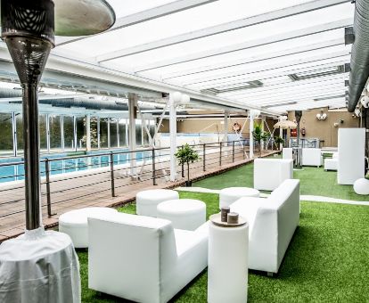 Terraza cubierta con mobiliario y piscina interior de este moderno hotel ideal para parejas.