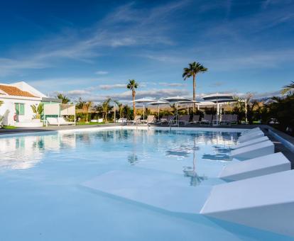 Foto de la piscina de agua salada con tumbonas del hotel.