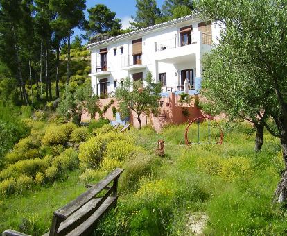 Edificio de este acogedor hotel rural rodeado de jardines y vegetación.
