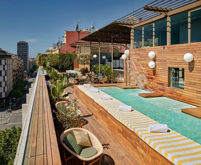 Vista de la piscina en la terraza con vistas al eixample donde puedes charlar o darte un baño mientras tomas el Sol en este hotel para adultos de la ciudad de Barcelona con tan buenas valoraciones.