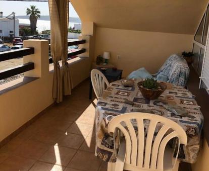 Foto del balcón con comedor exterior y vistas al mar del apartamento.