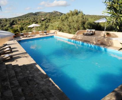 Foto de la piscina al aire libre disponible todo el año y rodeada de naturaleza de este hotel.