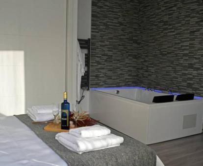 Bañera de hidromasaje privada cerca de la cama del apartamento de un dormitorio de este establecimiento.