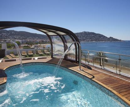Foto de la piscina al aire libre con chorros de hidroterapia del hotel y vistas al mar.