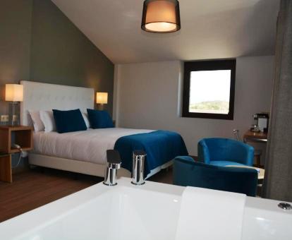 Foto de una de las suites con bañera de hidromasajes privada junto a la cama.