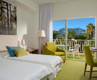 Foto de una de las habitaciones del hotel con terraza privada y vistas a las montañas.
