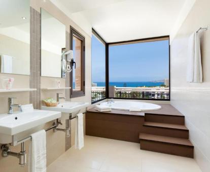 Bañera de hidromasaje privada con vistas al mar de la suite del hotel.