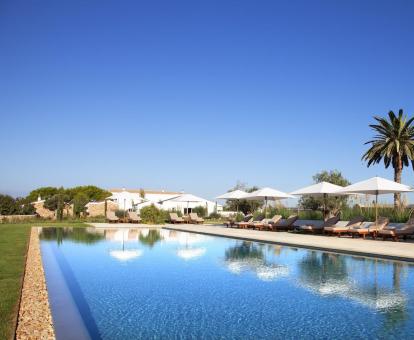 Foto de la fabulosa piscina al aire libre con amplios jardines y tumbonas.