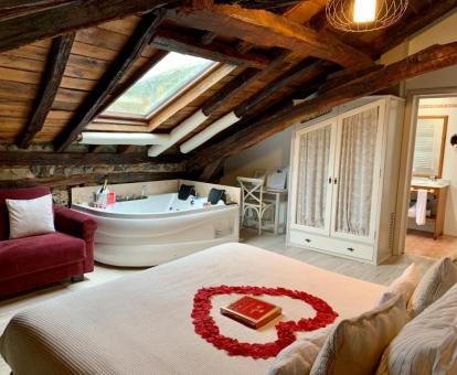 Foto de una de las Suites con bañera de hidromasajes privada junto a la cama.
