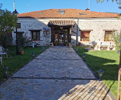 Edificio de estilo rústico con jardines de este acogedor hotel rural.