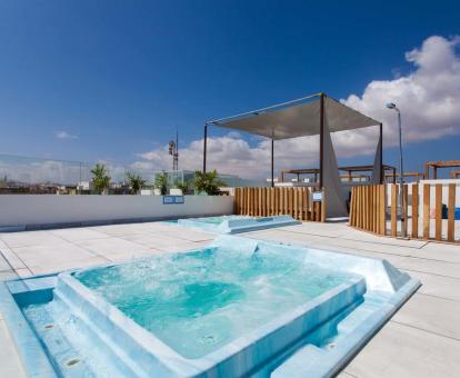 Foto de la zona de relajación en la terraza del hotel con jacuzzis y camas balinesas.