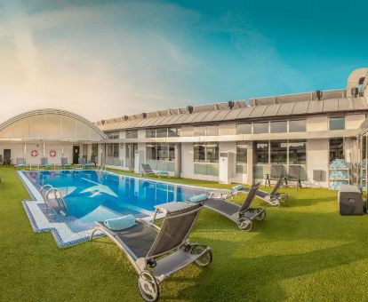 Agradable zona exterior con piscina rodeada de tumbonas de este lujoso hotel ideal para parejas.