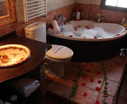 Baño con bañera de hidromasaje privada y decoración romántica de una de las habitaciones de este maravilloso hotel rural.