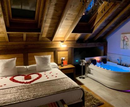 Foto de una de las románticas habitaciones con bañera de hidromasajes junto a la cama.