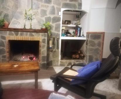 Foto de la sala de estar con televisión y chimenea de la casa.