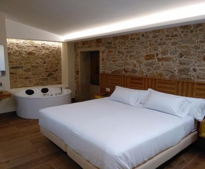 Dormitorio con un fabuloso jacuzzi privado junto a la cama de uno de los apartamentos del complejo.