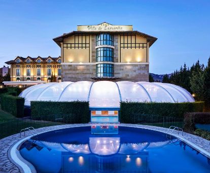 Edificio de este hermoso hotel romántico con piscina rodeado de vegetación.