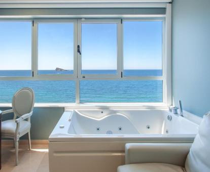 Acogedora zona con bañera de hidromasaje privada y vistas al mar de una de las habitaciones del hotel.