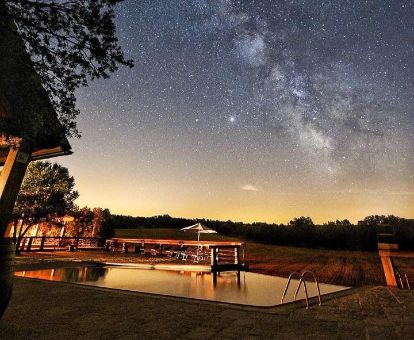 Maravillosa zona exterior con piscina de este hotel rural en una bella noche estrellada.