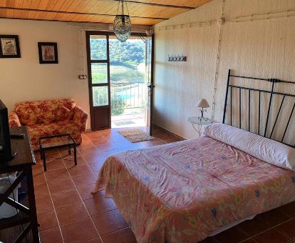 Acogedora habitación de estilo tradicional con balcón y vistas a la naturaleza que rodea el hotel.