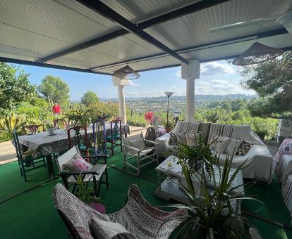 Terraza con mobiliario y vistas al paisaje que rodea este acogedor hotel rural.