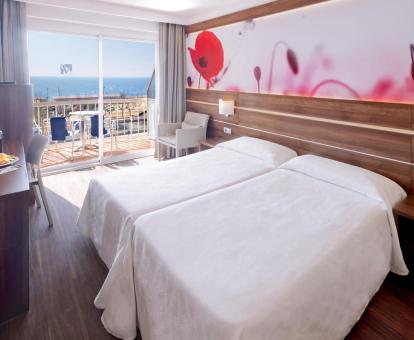 Foto de una de las románticas habitaciones del hotel con vistas al mar y terraza privada.