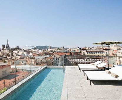 Terraza solarium con piscina y vistas a la ciudad de este elegante hotel.